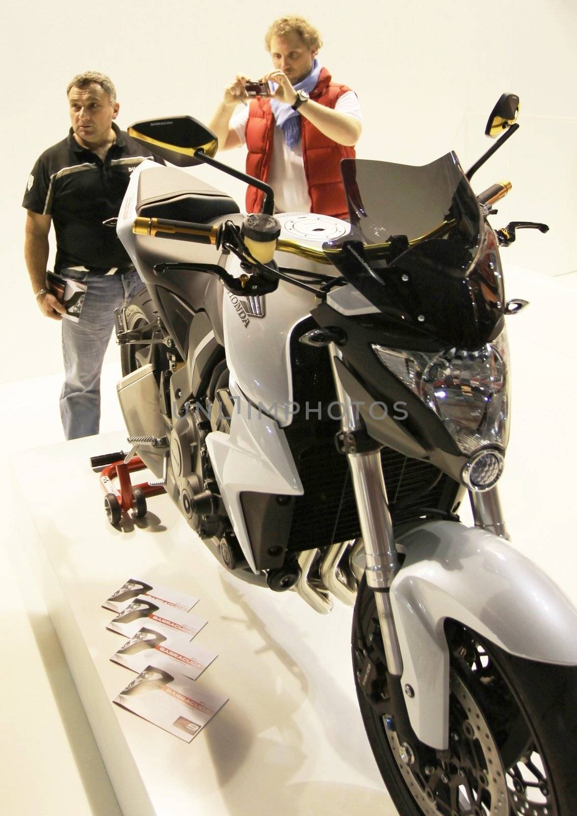 Looking at new motorcycles stands at EICMA, International Motorcycle Exhibition 2010 in Milan, Italy.