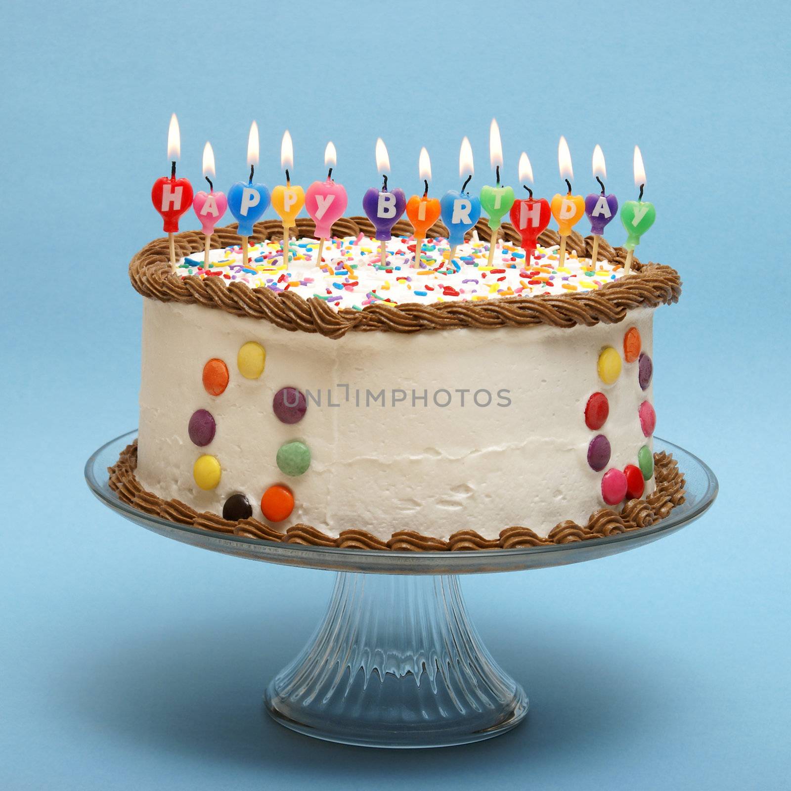 A cake and it's candles that read happy birthday.
