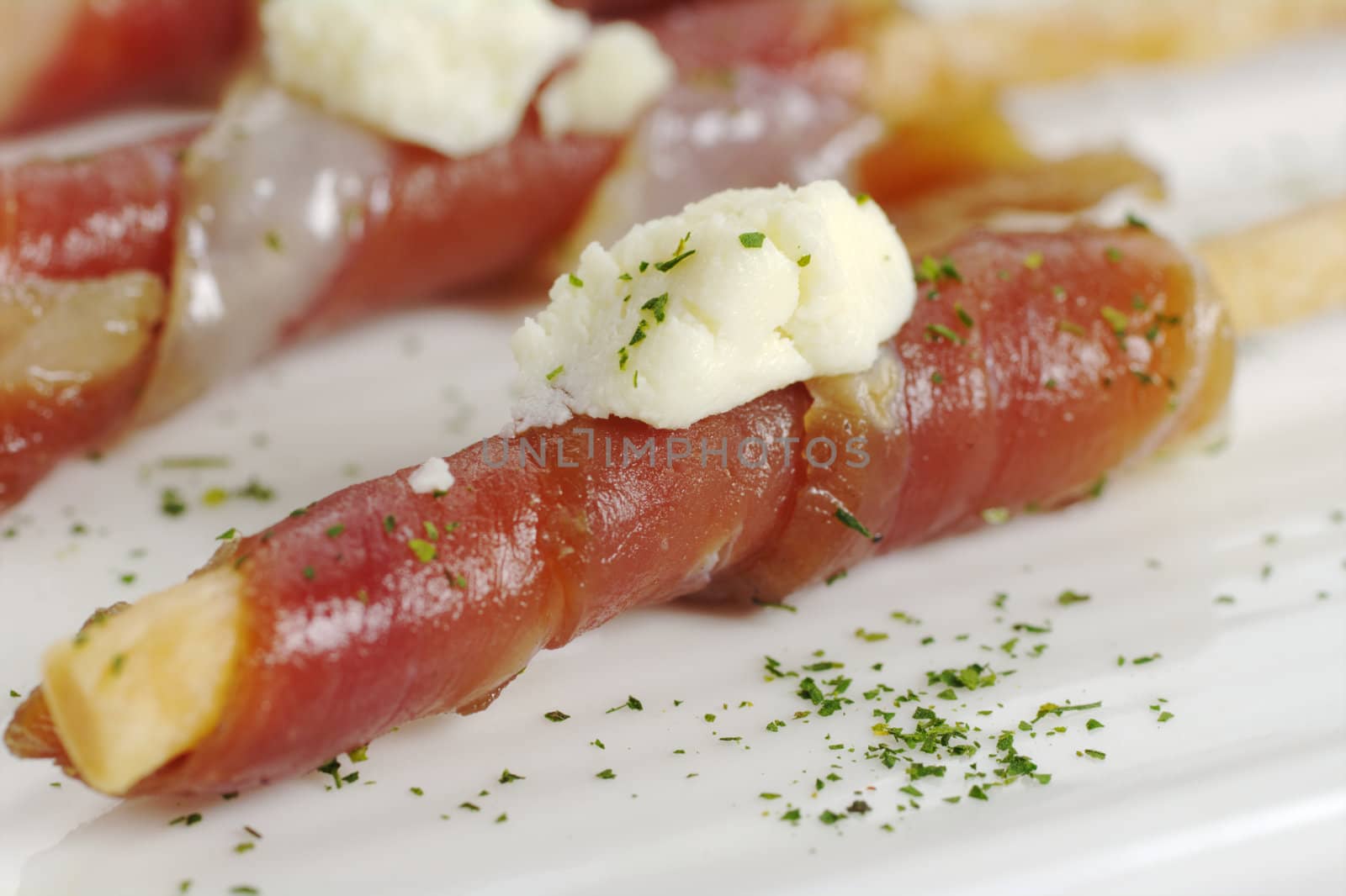 Appetizer: Bacon slice wrapped around salt stick with a piece of cheese on top (Selective Focus)