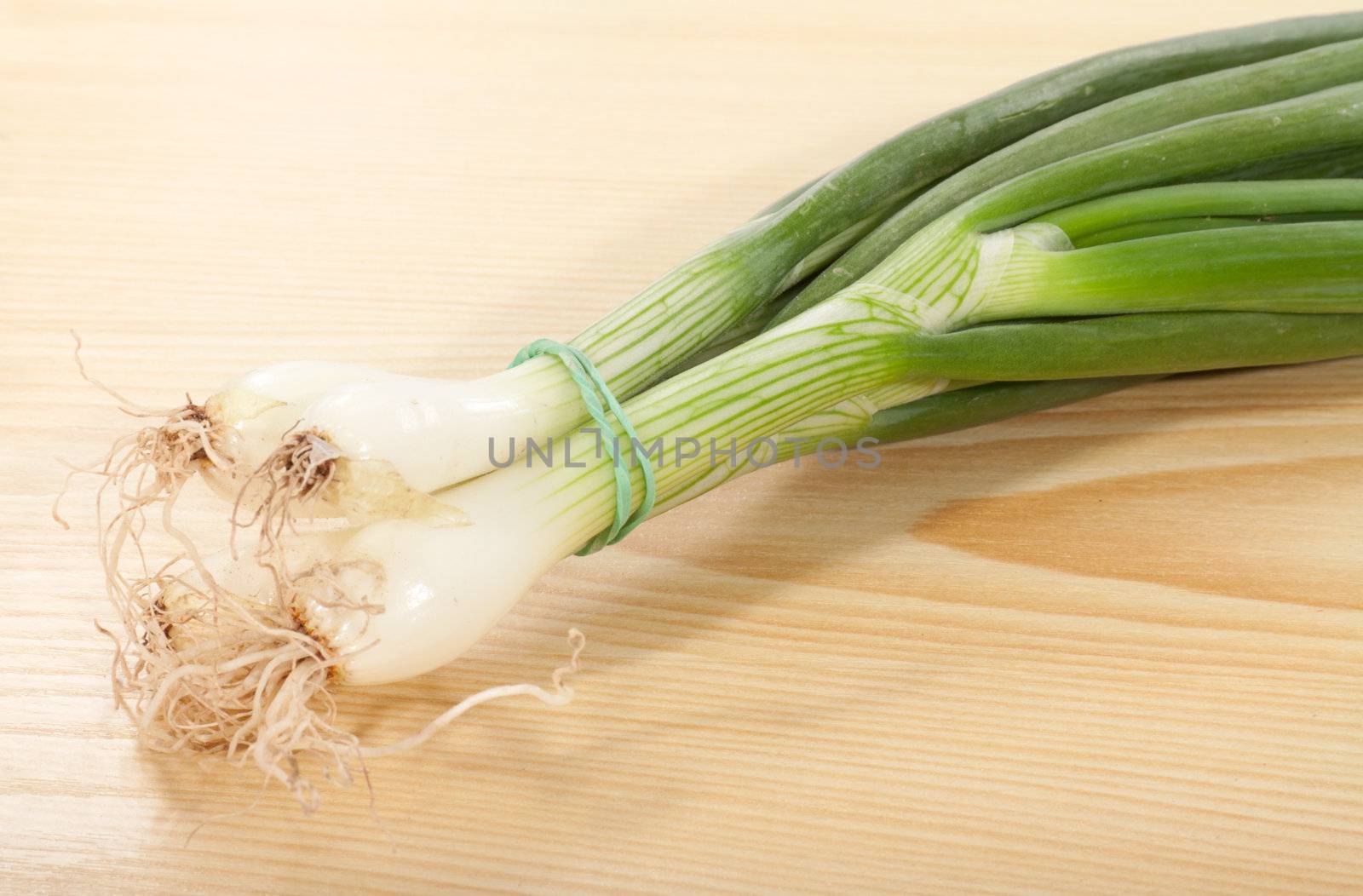 bunch of spring onions on a wooden table