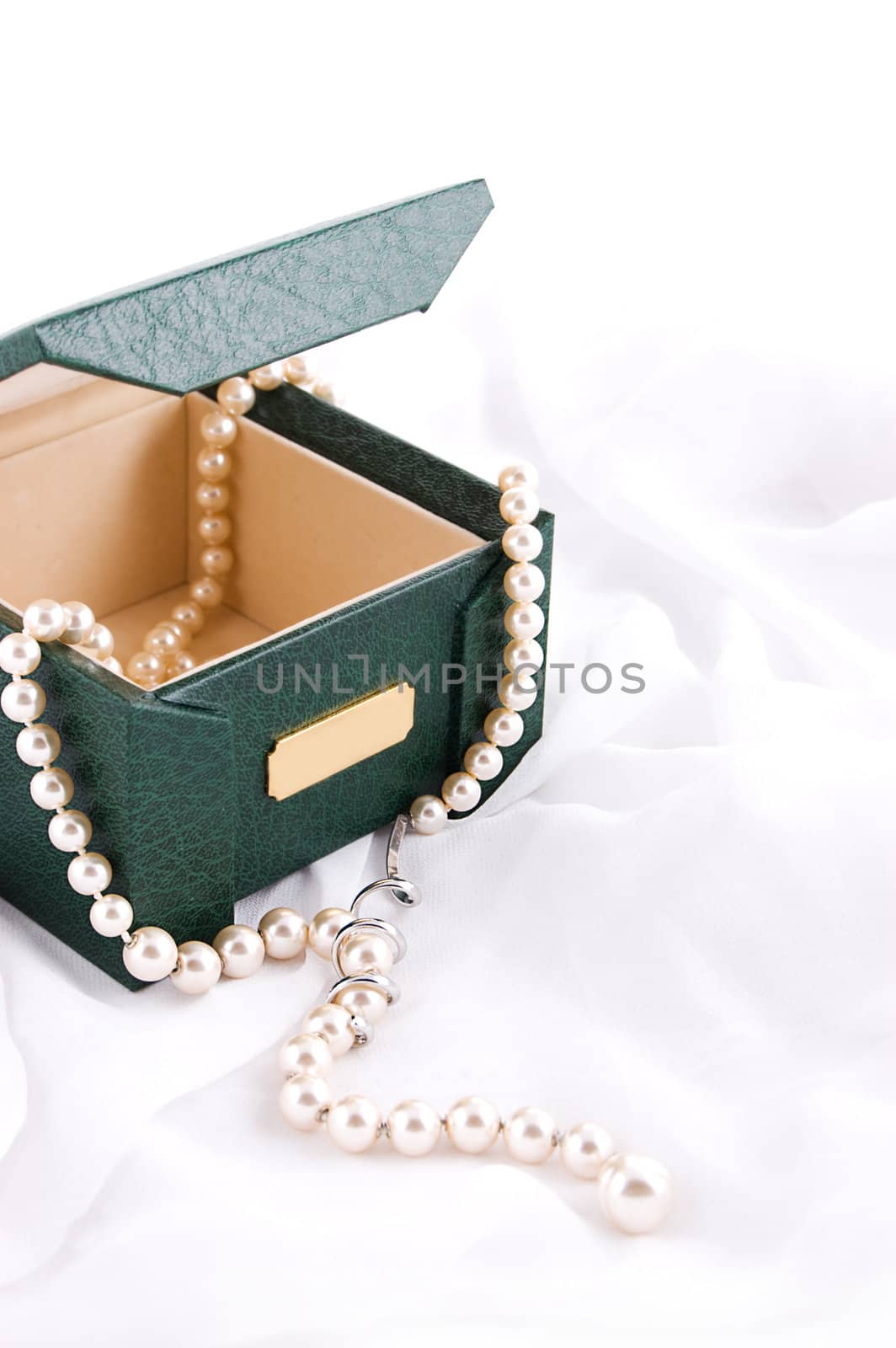 Pearl necklace in box over white fabric