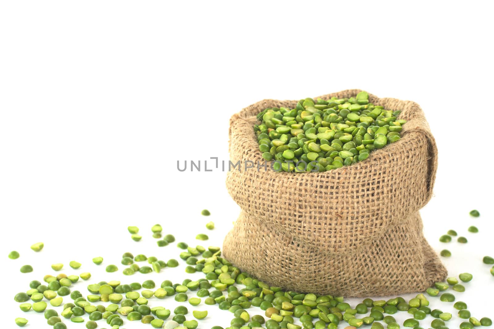 Split dried green peas in jute sack on white (Selective Focus, Focus on the peas in the front in the sack)