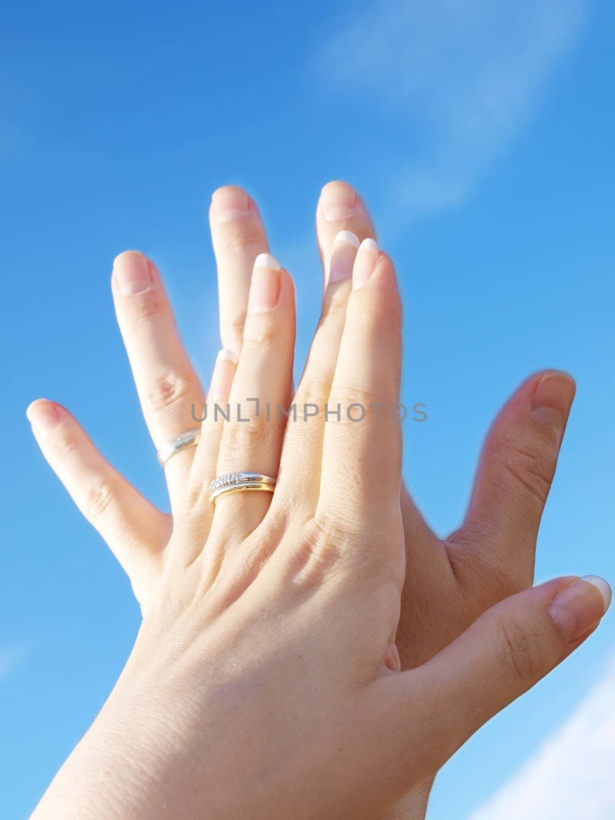 Married couple holding hands towards fresh blue sky