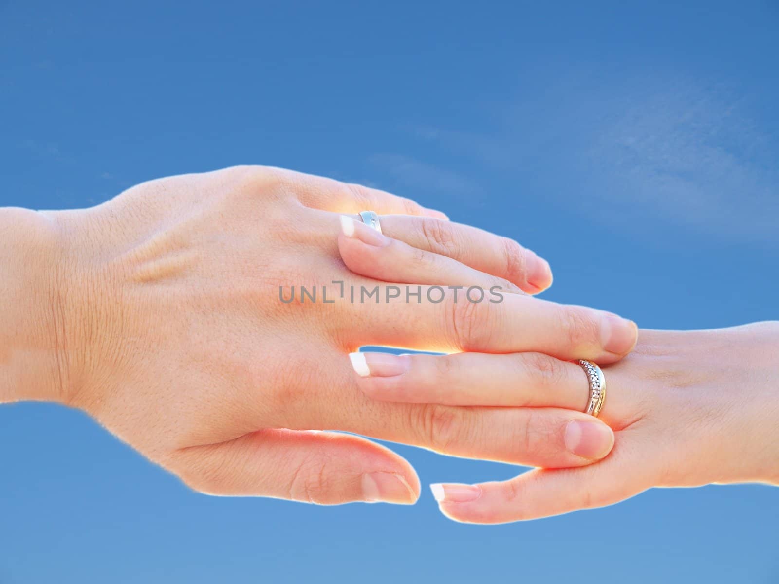 Married couple holding hands towards fresh blue sky