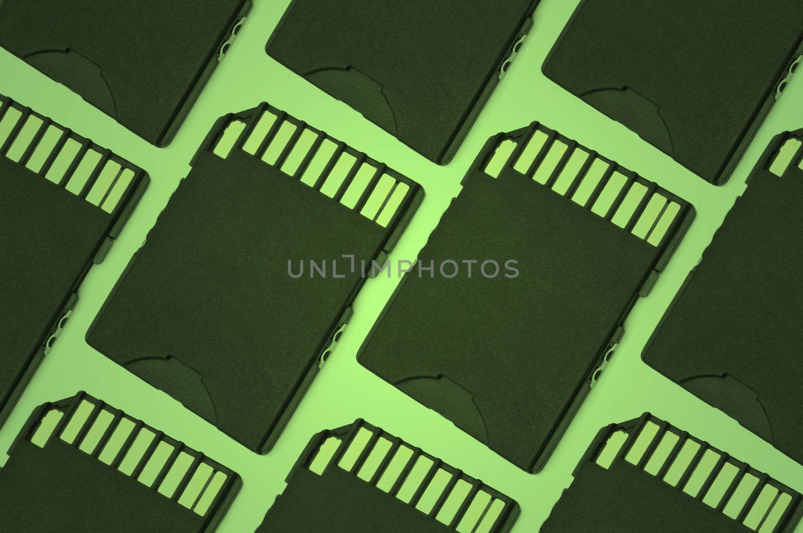 Close up on a row of black SD memory cards arranged with green filter