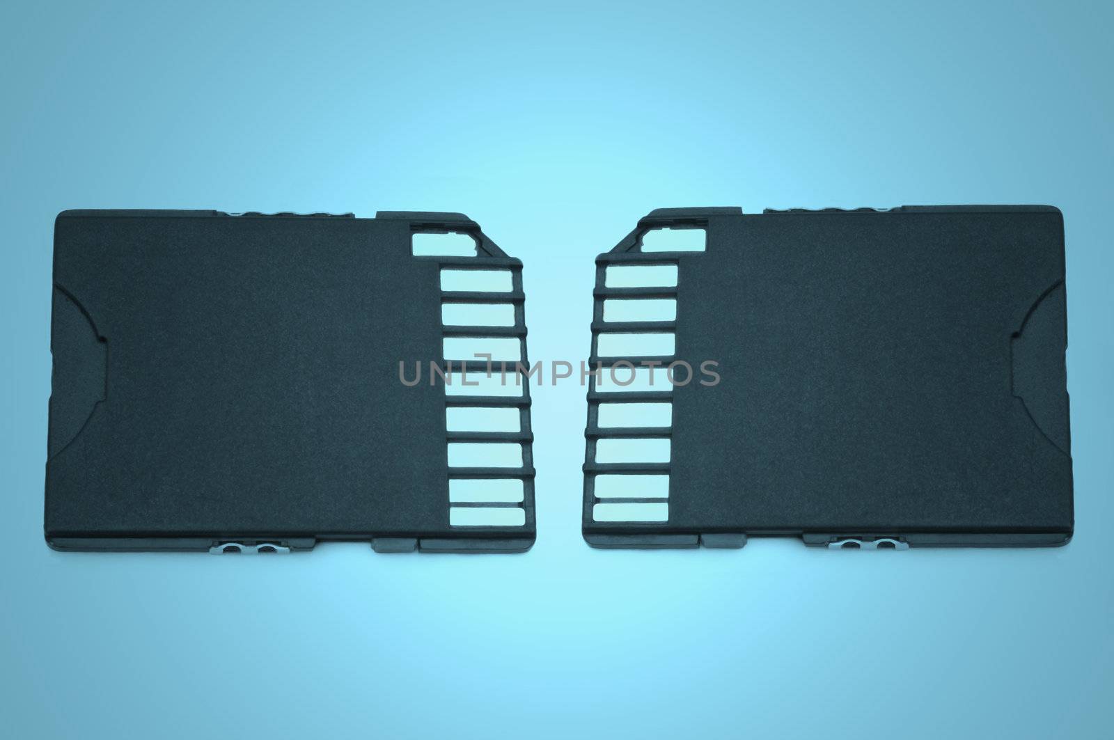 Close up on two black SD memory cards arranged over blue light filter