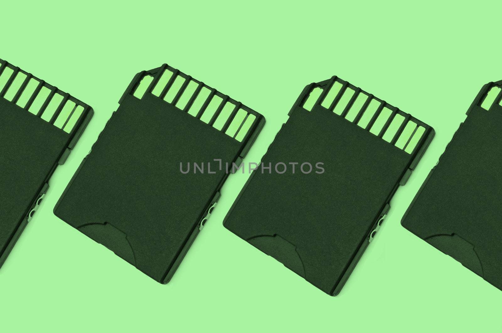 Close up on a row of black SD memory cards arranged with green filter