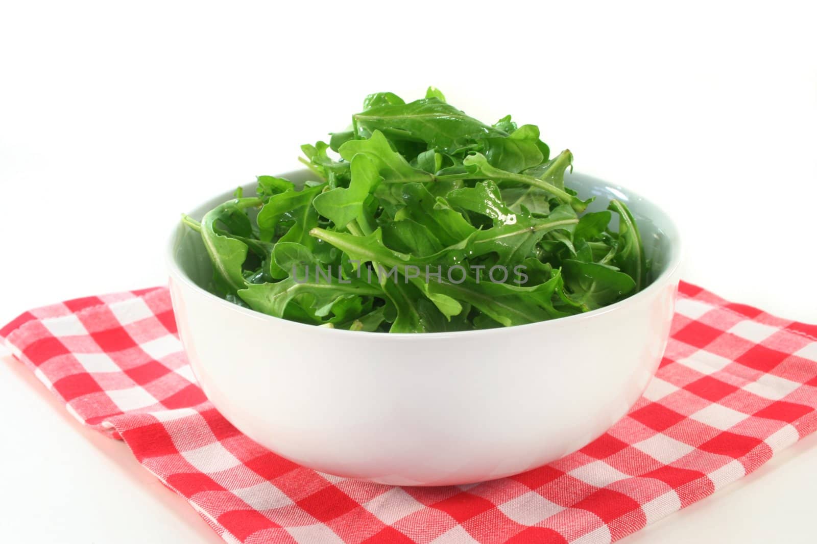 fresh rocket leaves in a white bowl