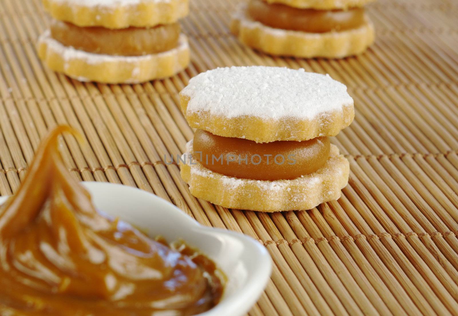 Peruvian cookie called Alfajor filled with a toffee-like cream called Manjar, with the cream in the front (Selective Focus, Focus on the alfajor in the middle)