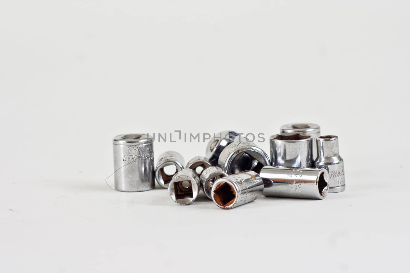 Pile of different size scokets on a white background.