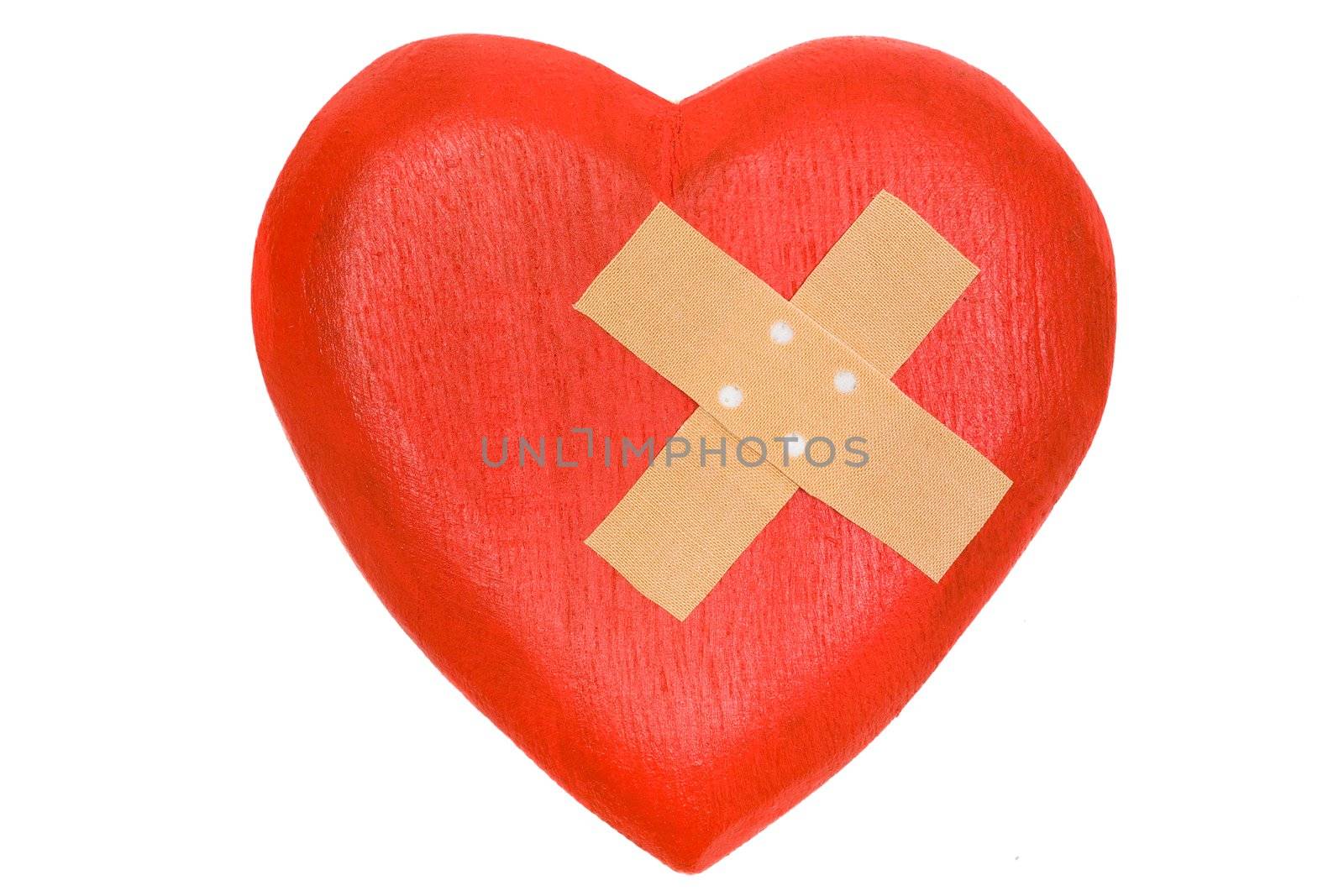 Wooden heart with a plaster. Isolated on a white background.