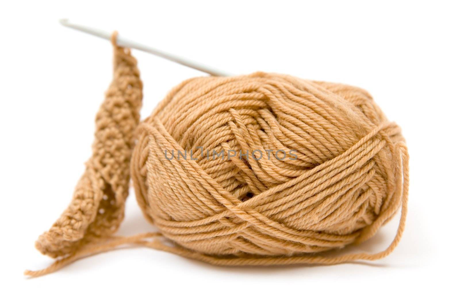 Brown yarn and crotchet hook. White background.
