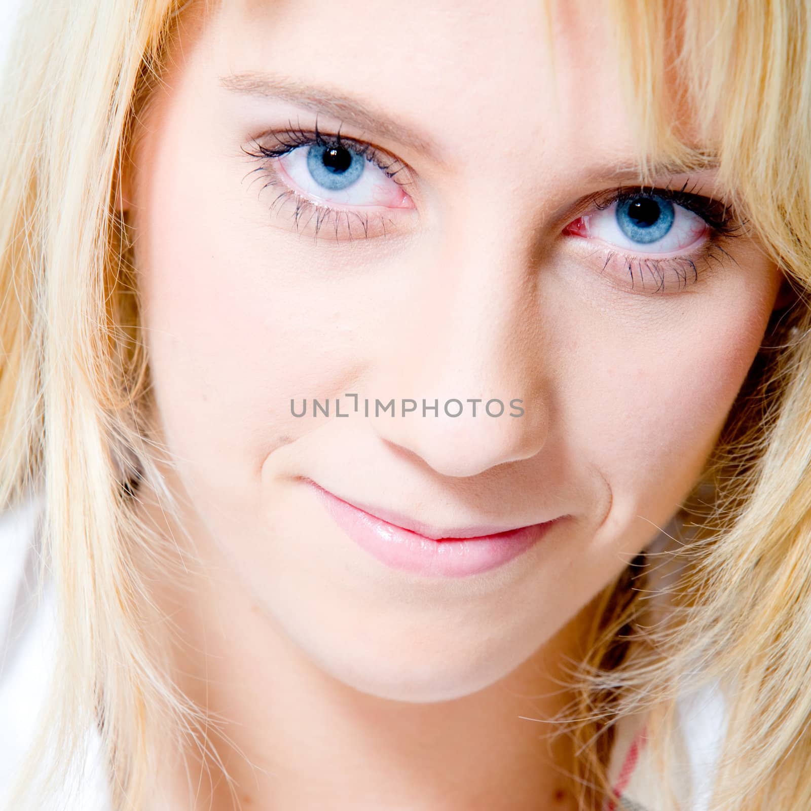 Studio portrait of a long blond girl looking friendly