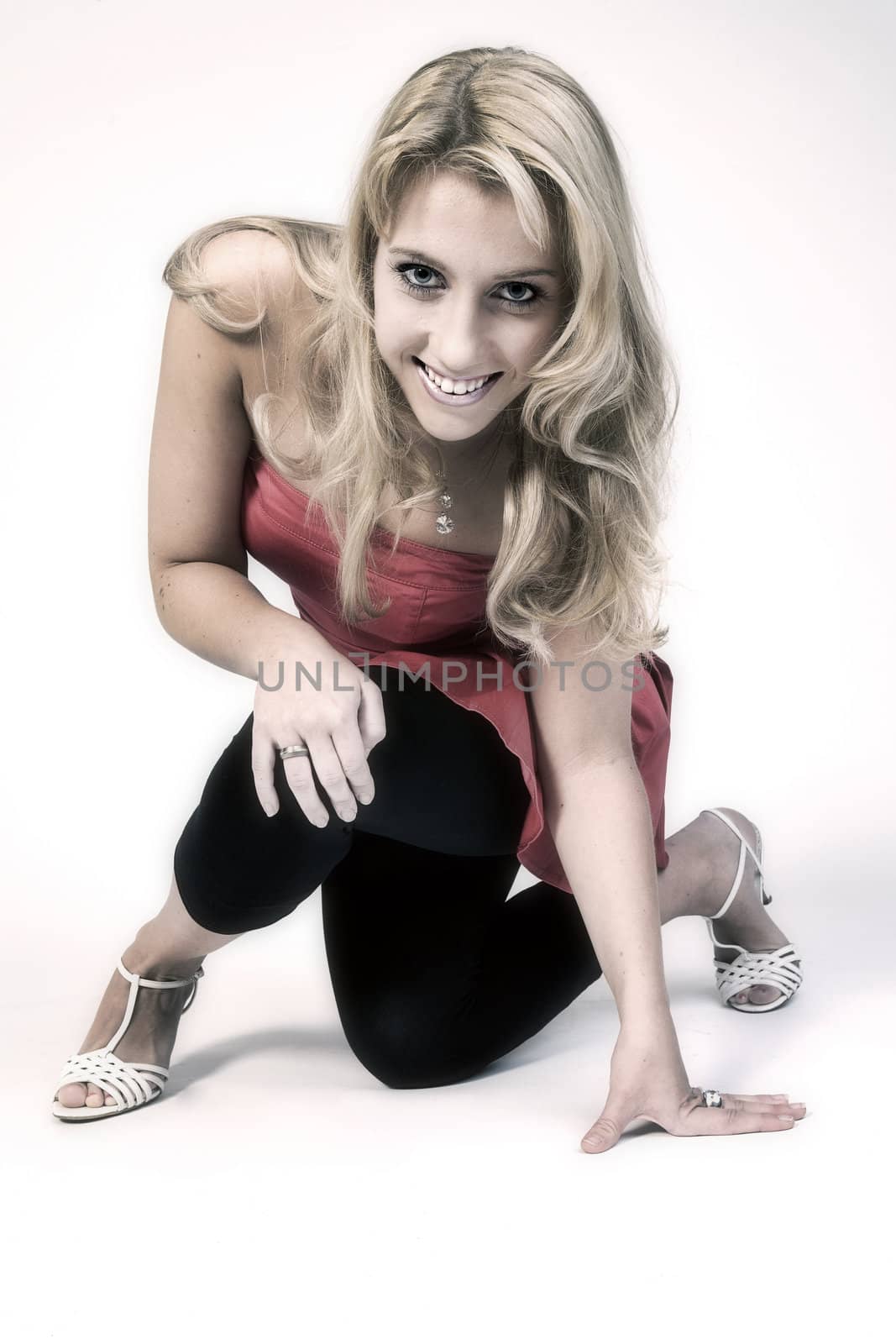 Studio portrait of a long blond girl  sitting on one knee