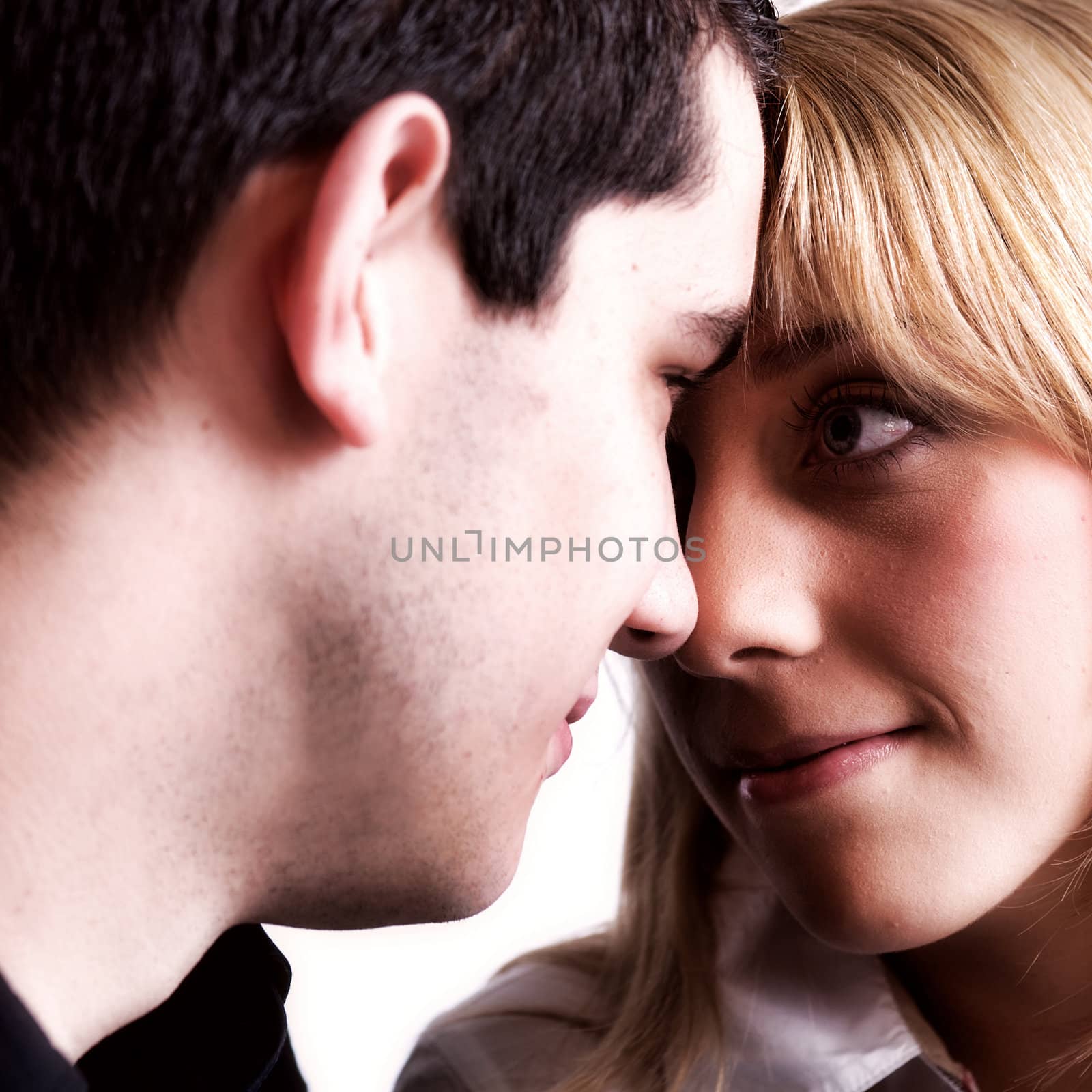 Studio portrait of a young couple touching noses