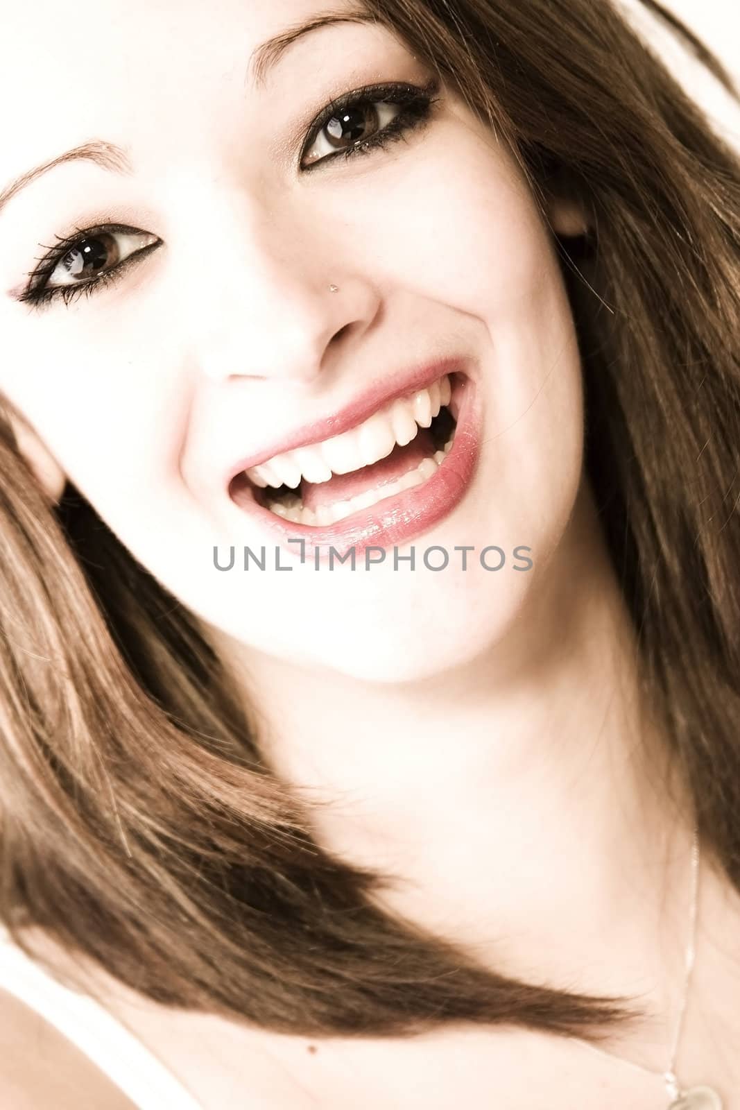 Studio portrait of pretty brunette laughing hard