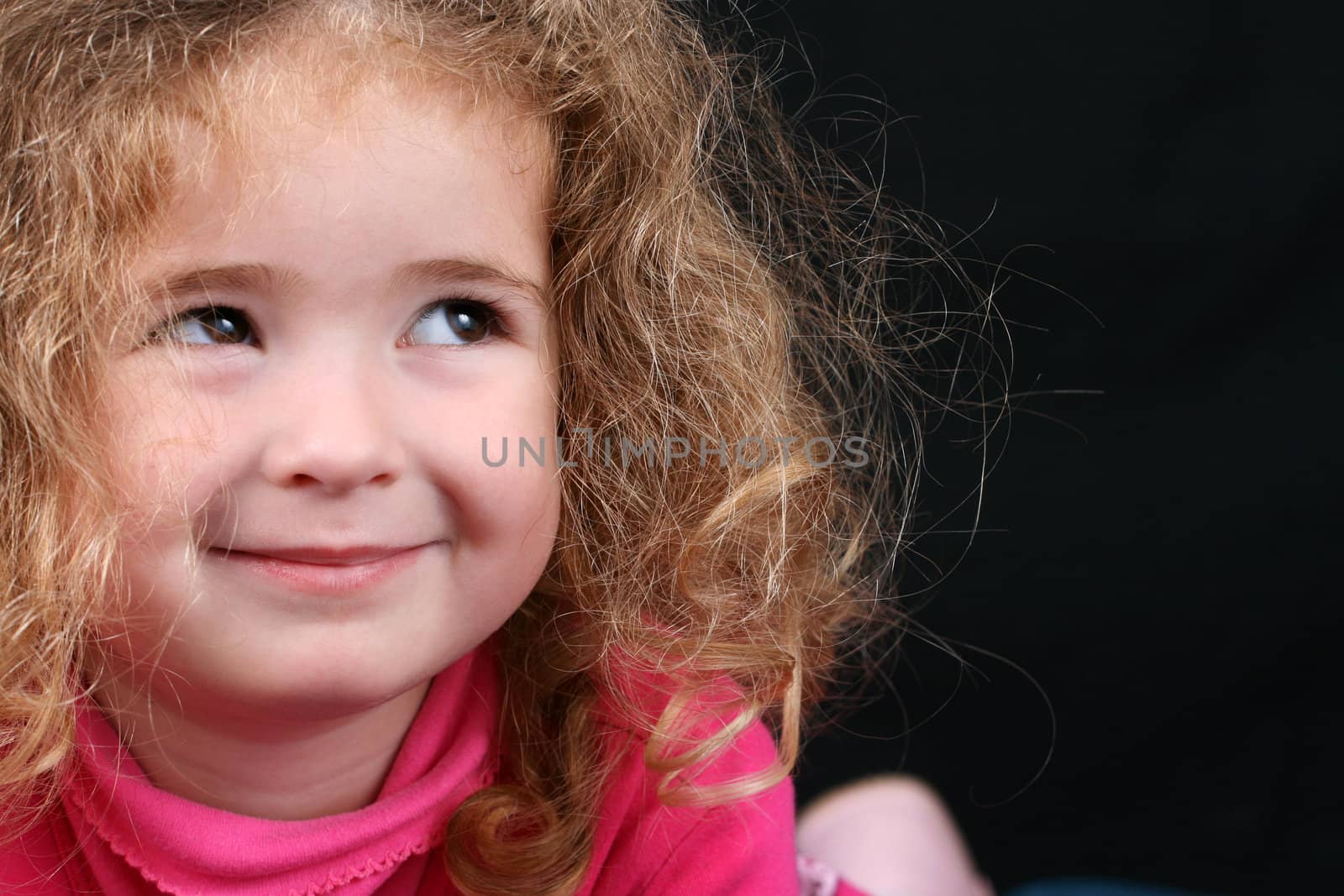 Beautiful young girl with curly hair and cute features
