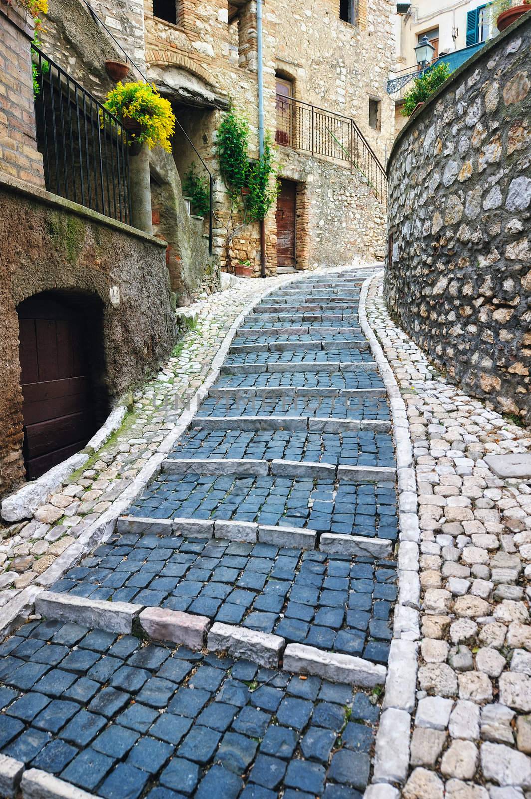 Sidewalk between old homes paved with the cobblestones