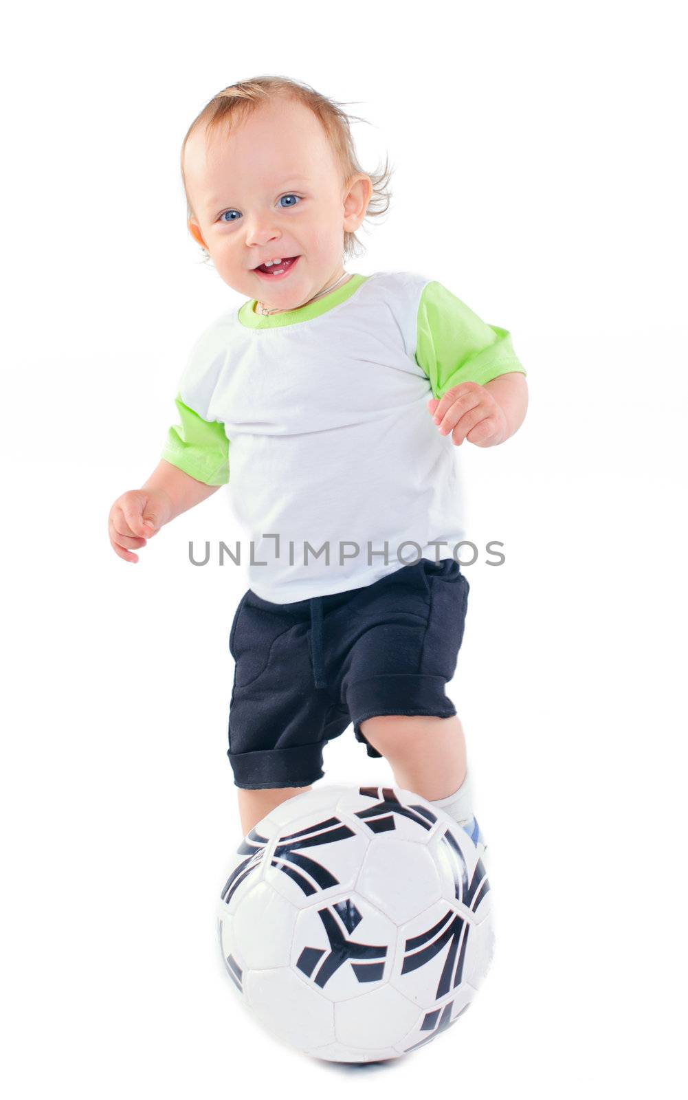 Cute 1 years old boy in sports form with a soccer ball in the studio