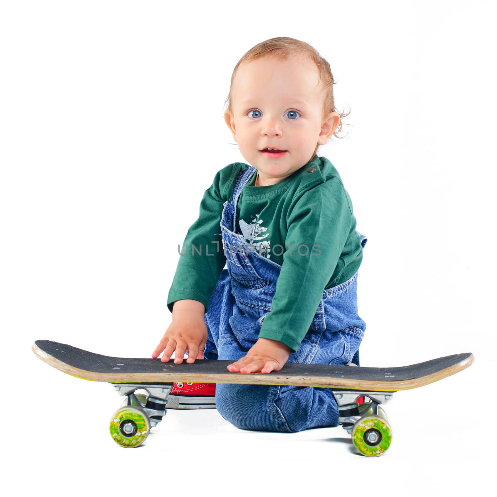Cute 1 years old boy on a skateboard in the studio