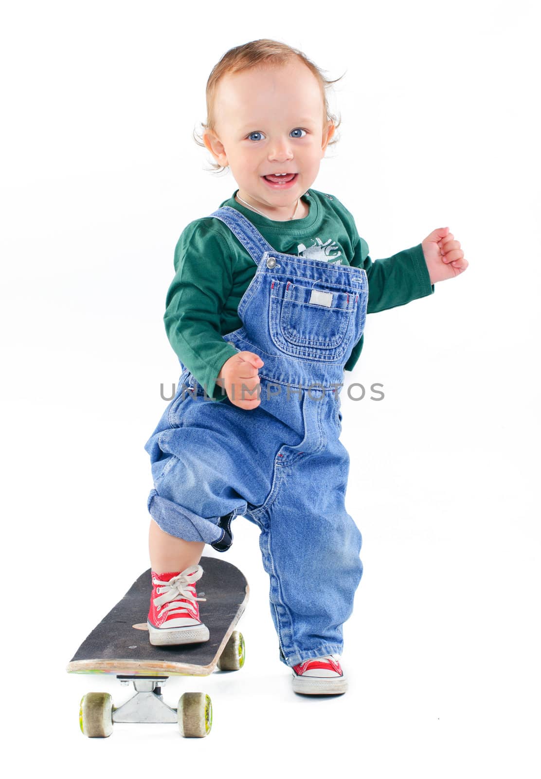 Cute 1 years old boy on a skateboard in the studio