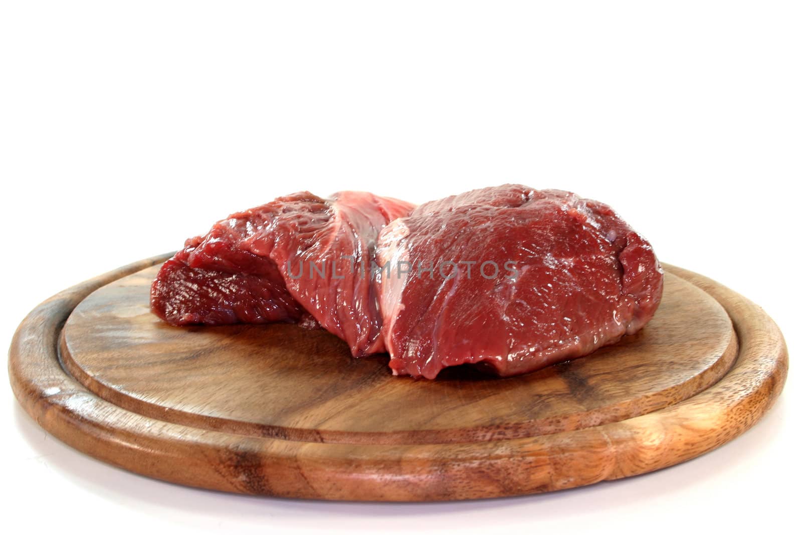a piece of beef steak hip on a wooden board
