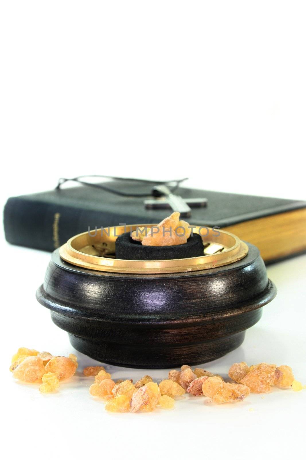 Incense bowl and song book in front of white background