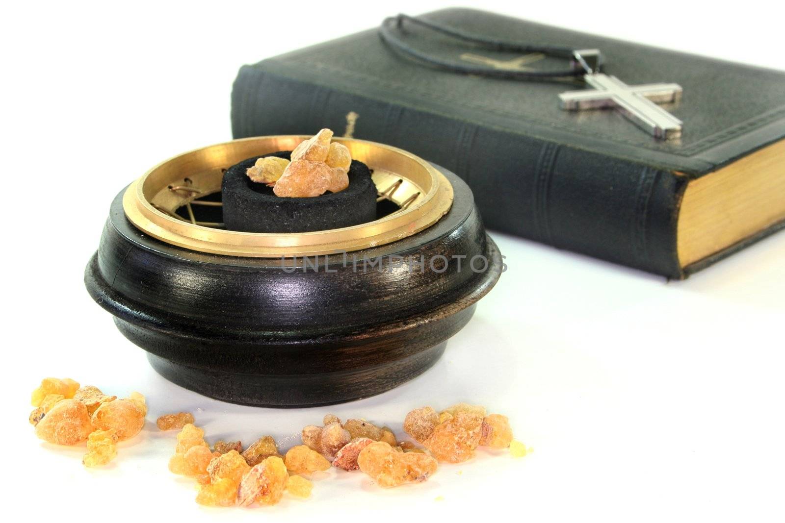 Incense bowl and song book in front of white background
