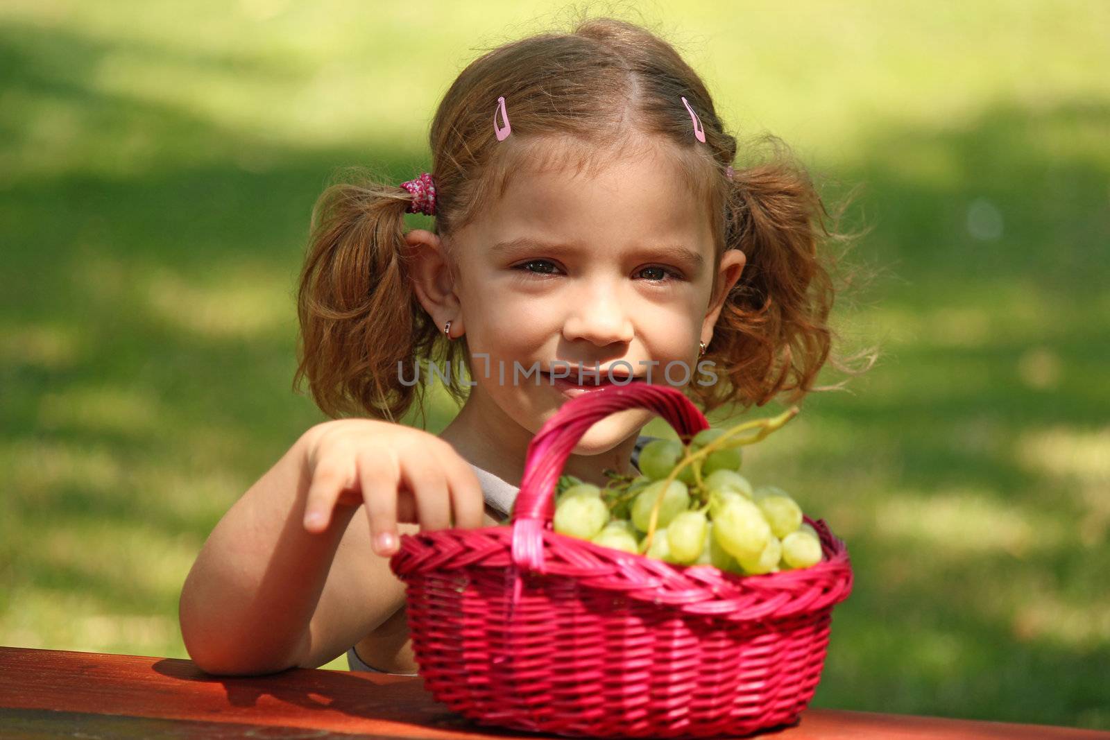 little girl eat grape