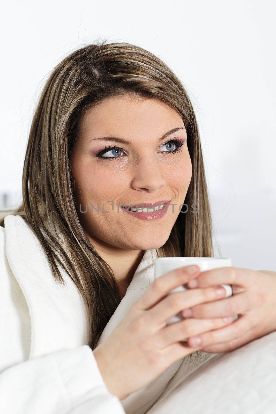 young woman on sofa with cup of coffee