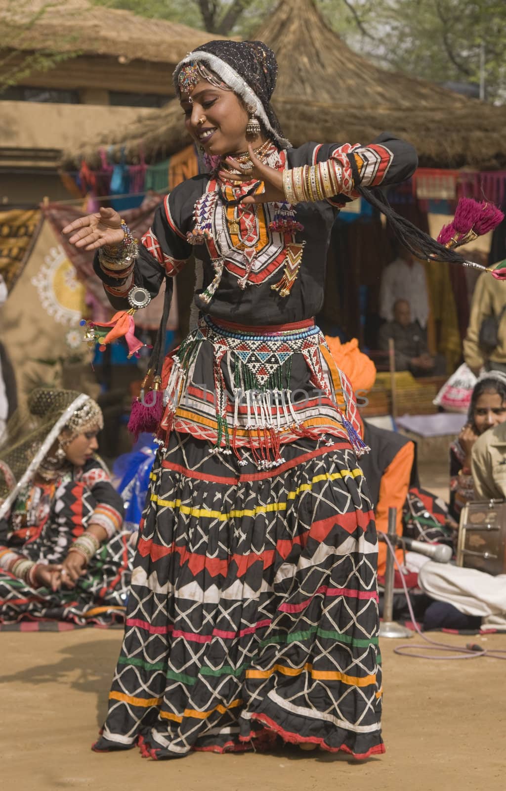 Rajasthani dancer in ornate black costume trimmed with beads and sequins performing at the Sarujkund Fair near Delhi in India.