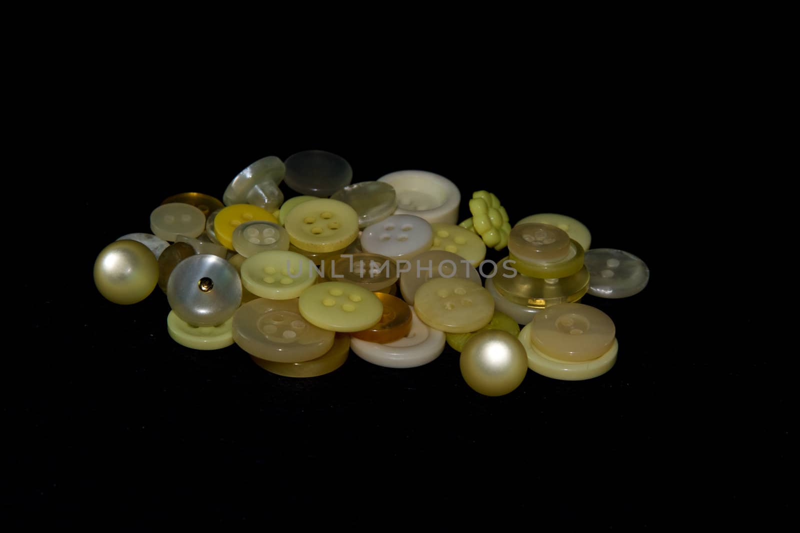 A pile of a variety of yellow buttons.