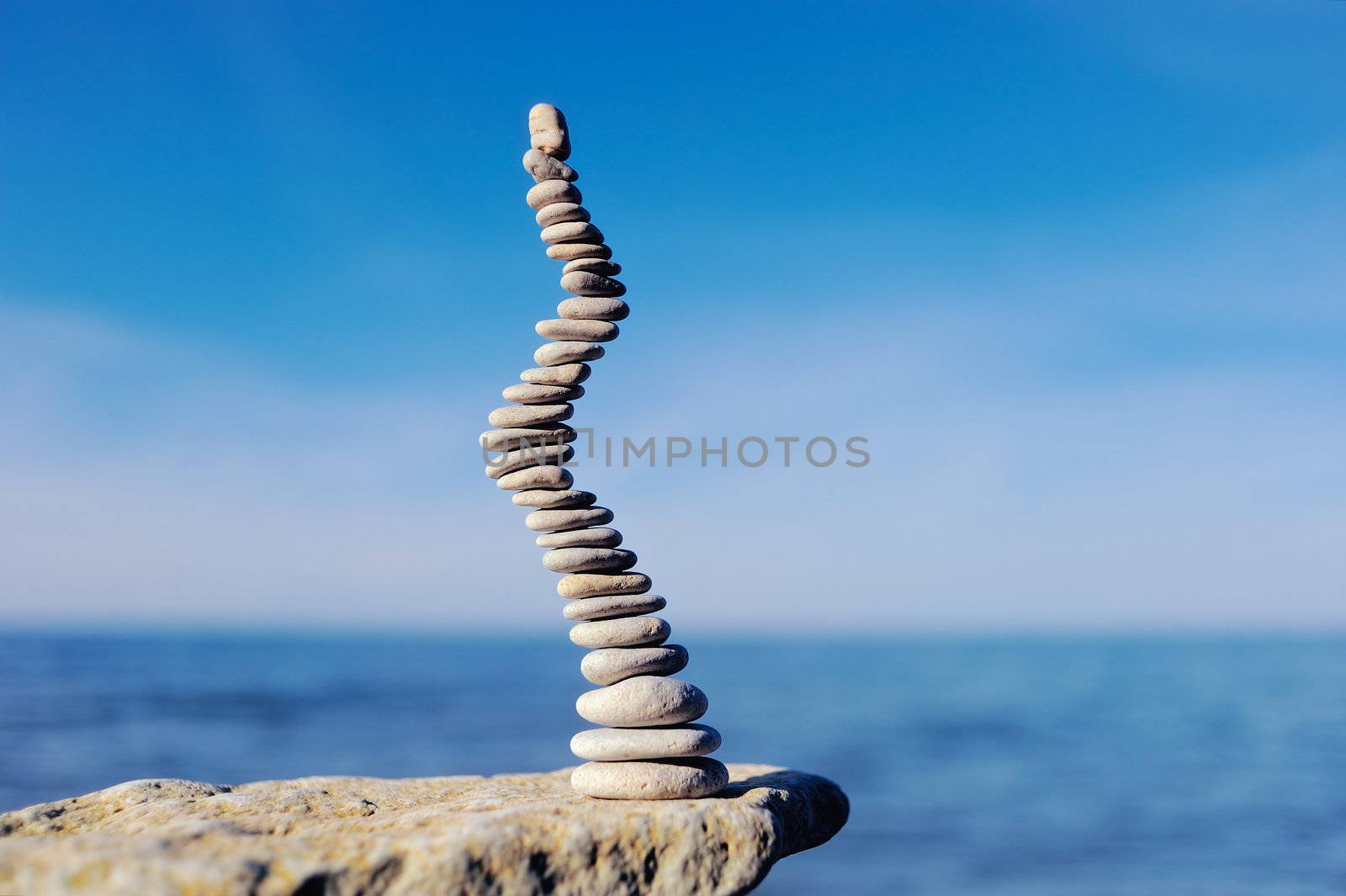 Pile of small pebbles in the balance on the seacoast