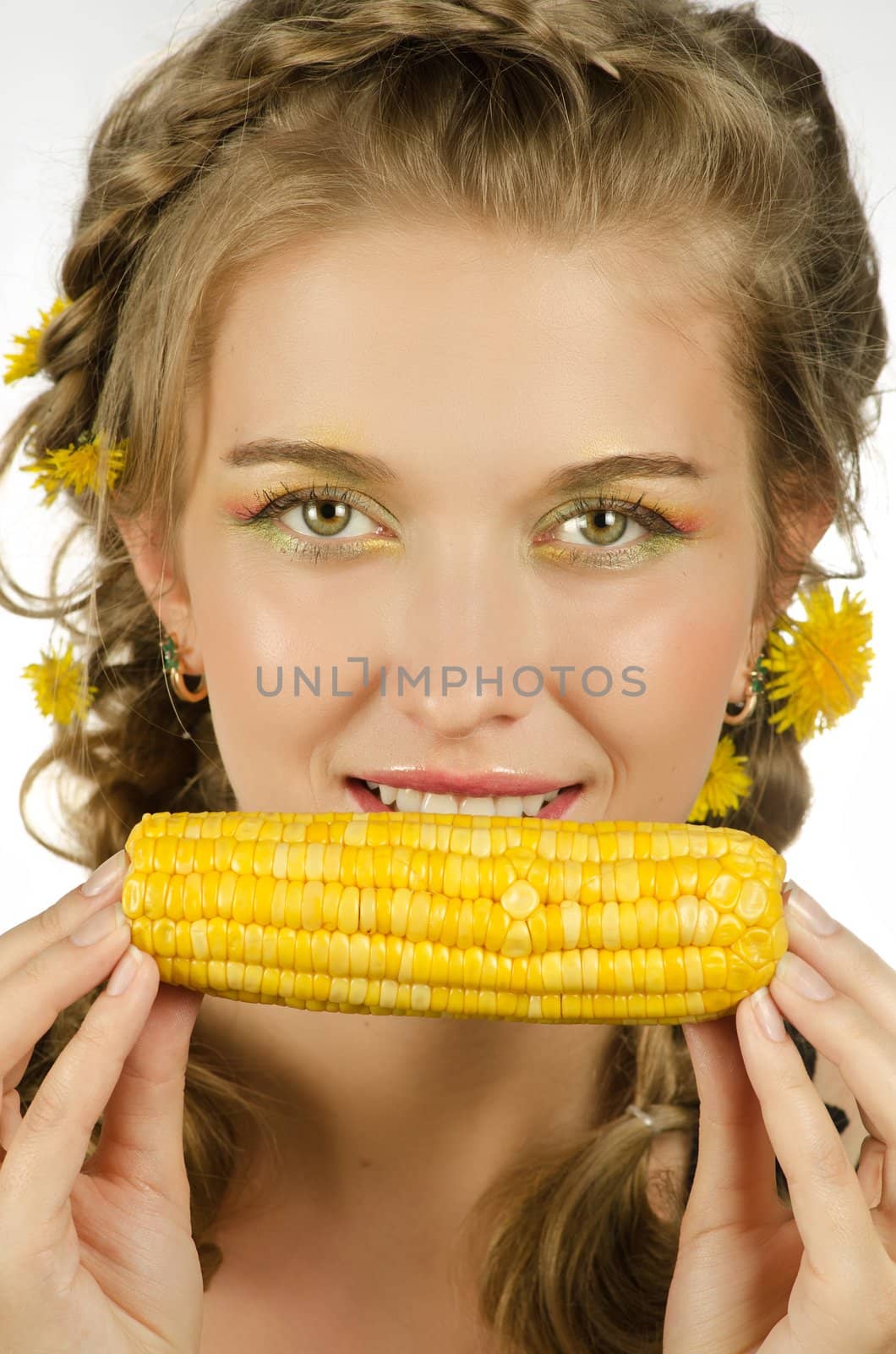Close-up portrait of young beauty woman eating corn-cob on a white