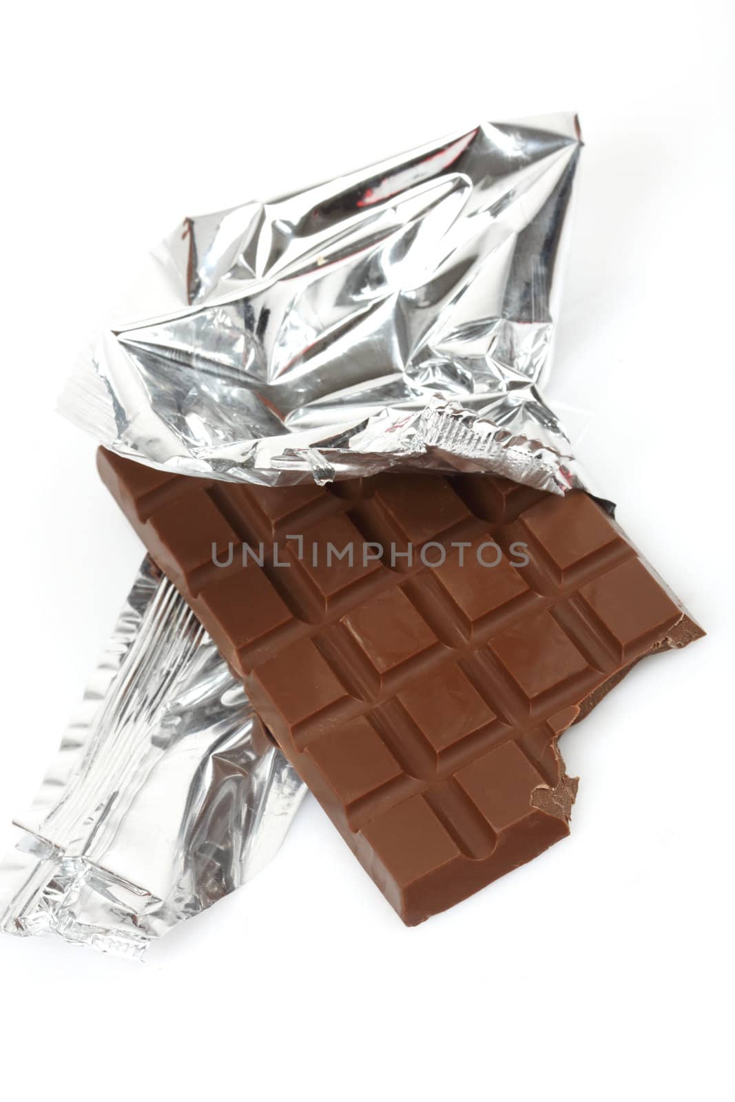 Chocolate bar in foil close up over white