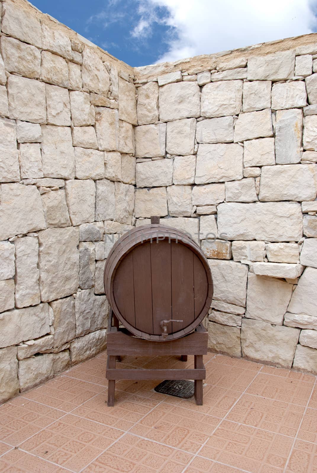 An old Wine Barrel in a Greek Courtyard under a blue summer Sky