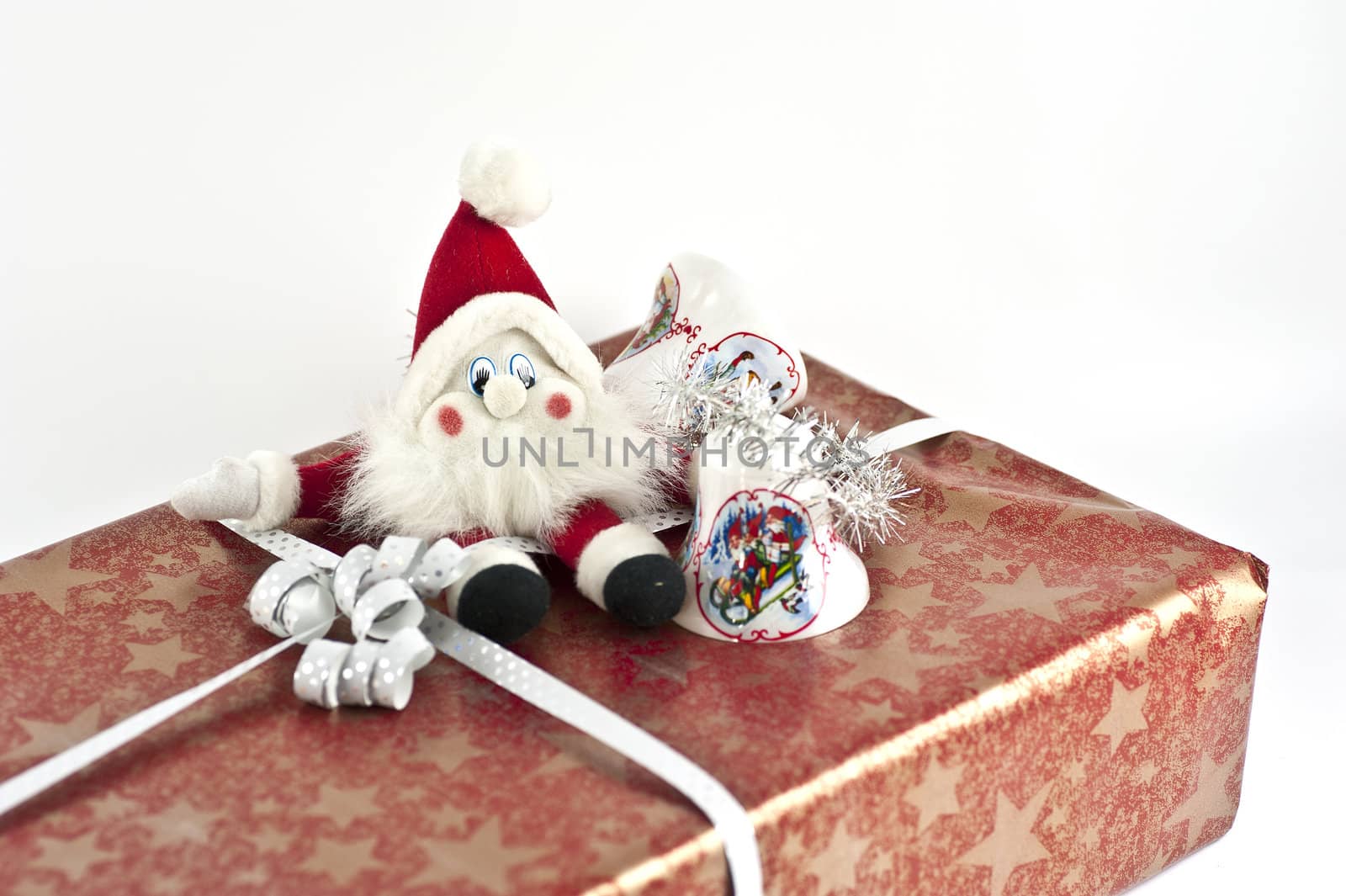 Christmas present with a santa doll and some jingle bells on top