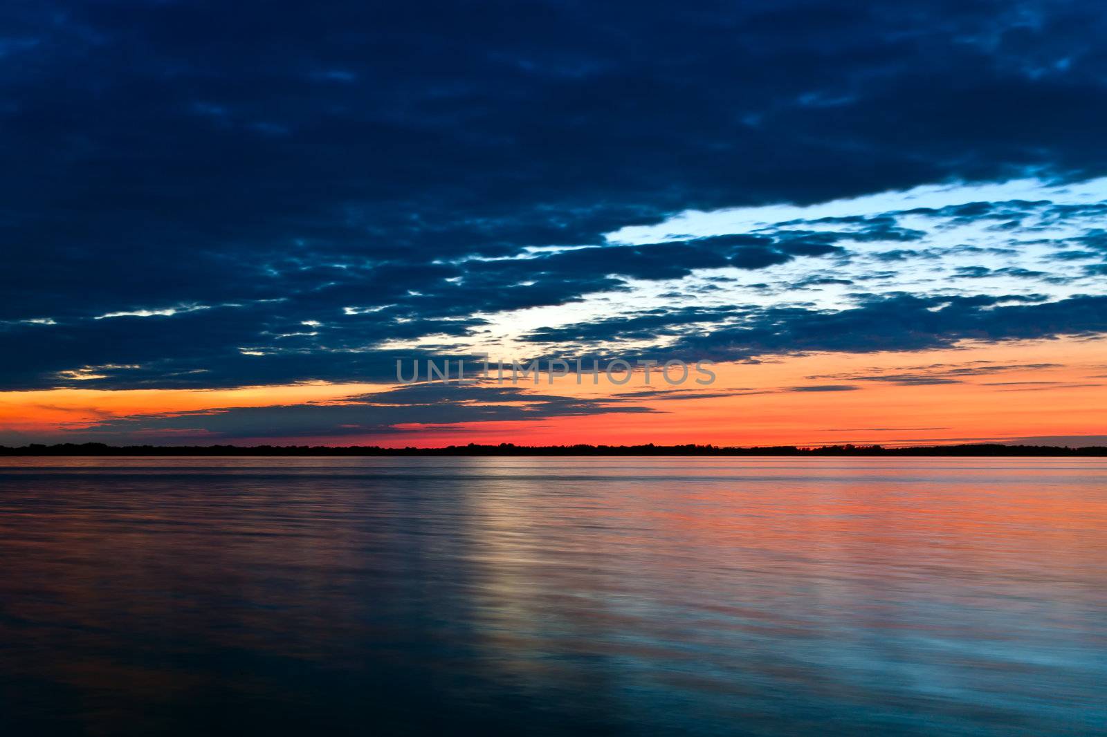 Scenic seascape view at sunset with cloudscape background.