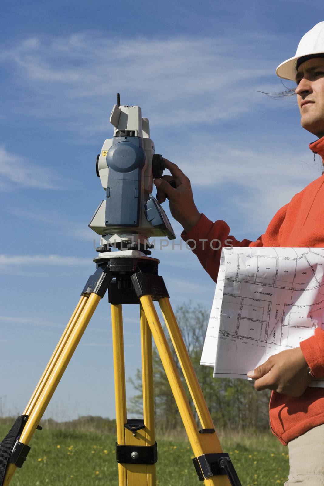 Land Surveyor in the field with theodolite on the tripod.