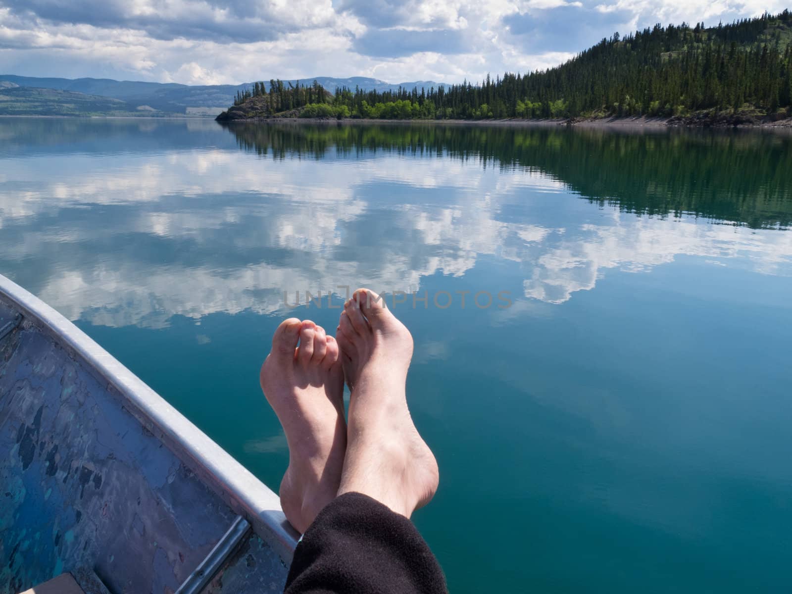 Relaxing in motorboat drifting on calm Lake Laberge, Yukon Territory, Canada.
