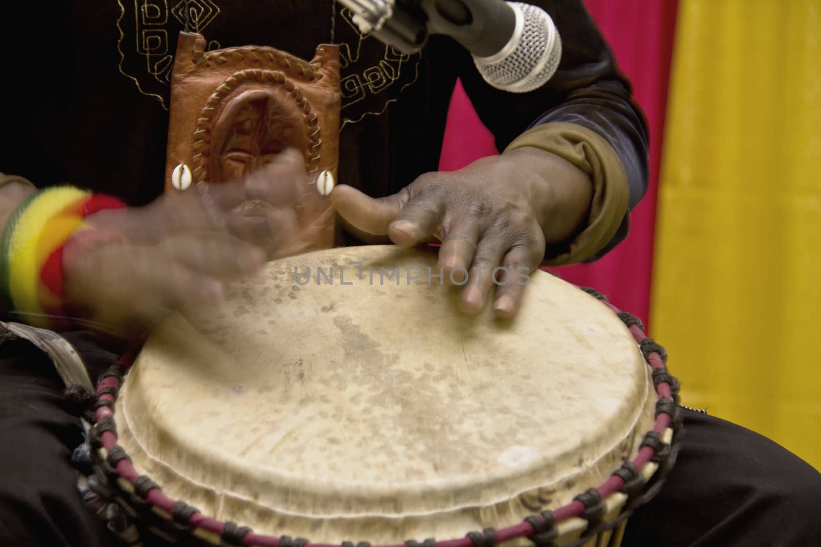 An african man playing a traditional drum by hand