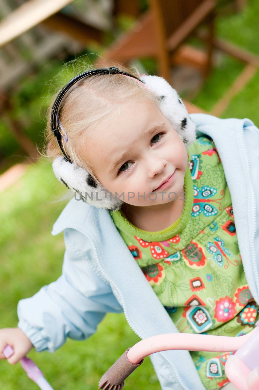 Shot of little girl in headphones playing outside
