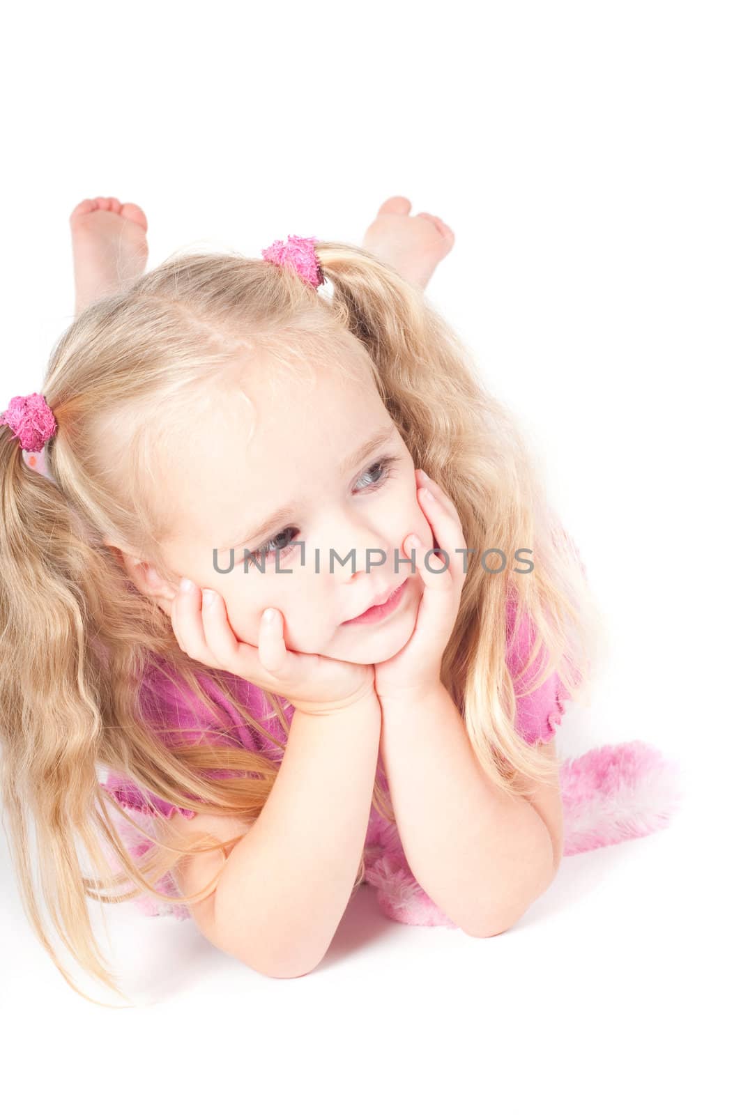 Little cute girl in pink and with ponytails in studio