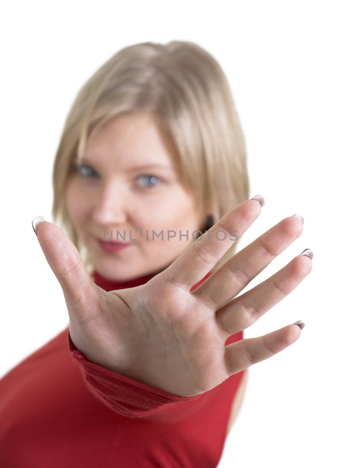 Pretty young adult woman in red making a "stop" gesture, focus on palm. Isolated on white background, copy space.