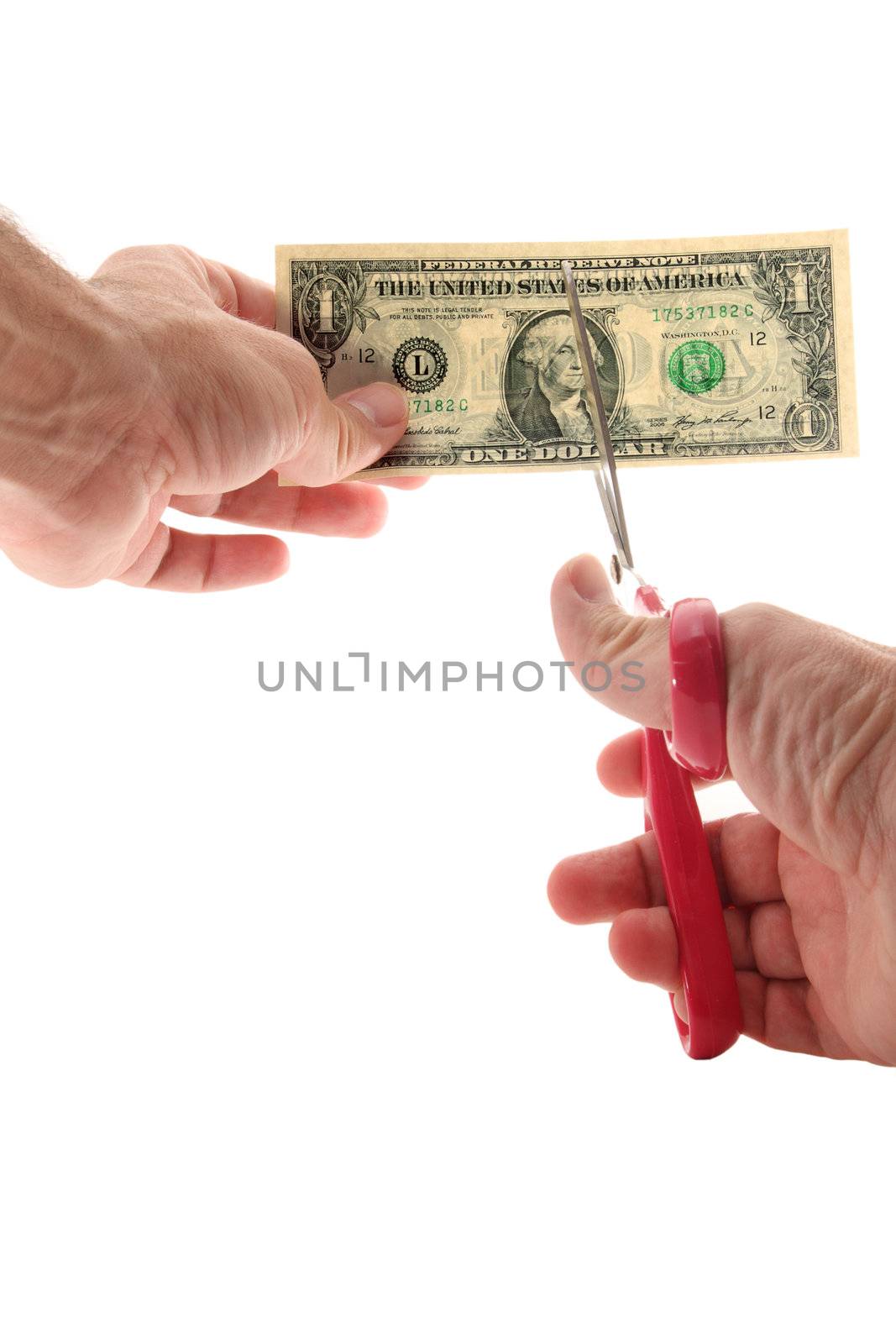 Man using scissors to cut US $1 bill
