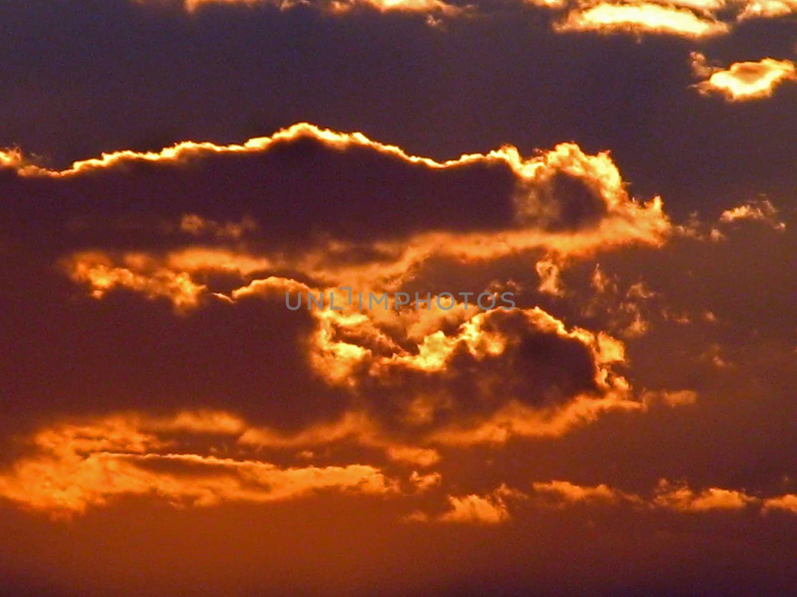 A red and golden burning sunset with clouds.