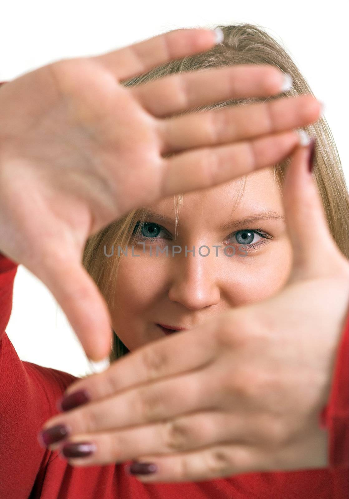 Pretty adult blonde looking through a frame made by her hands; isolated on white
