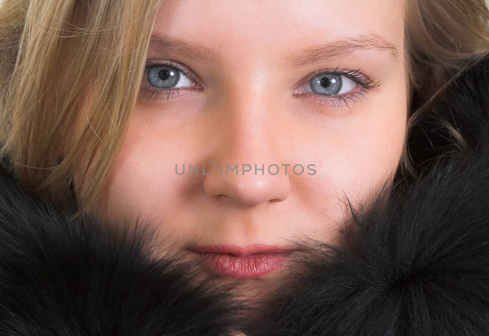 Head portrait of a pretty young lady in a black fur coat