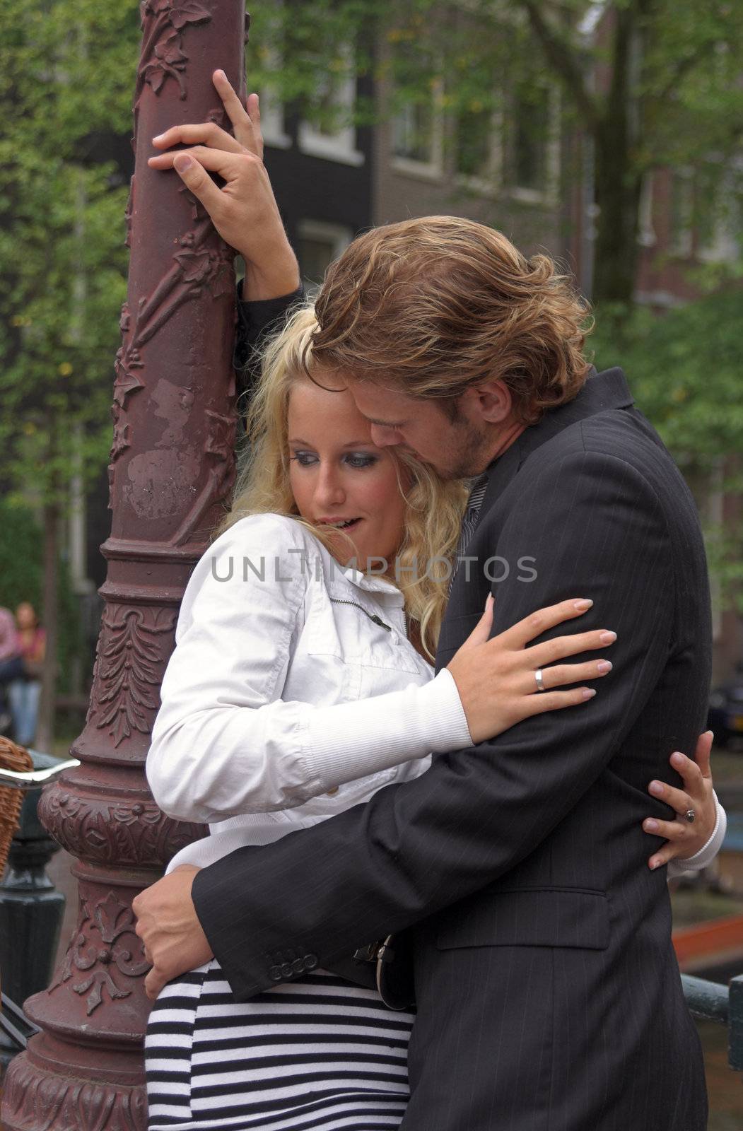 Young adult couple embracing at a street lamp post