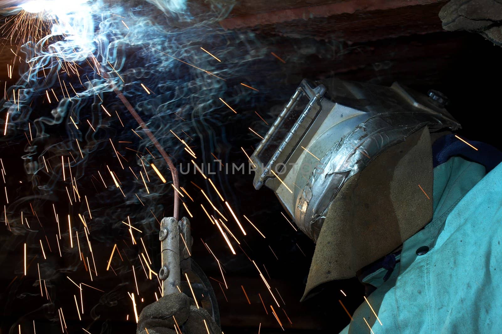 a welder working at shipyard under vessel